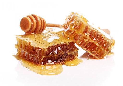why is manuka honey so expensive: hero image of honey dipper and honeycomb