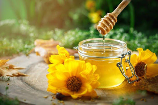 Manuka Honey Vs Raw Honey: syrup dipper with honey jar